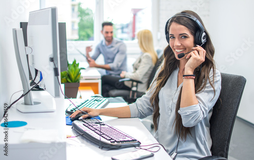 Slika na platnu Portrait of happy smiling female customer support phone operator at workplace