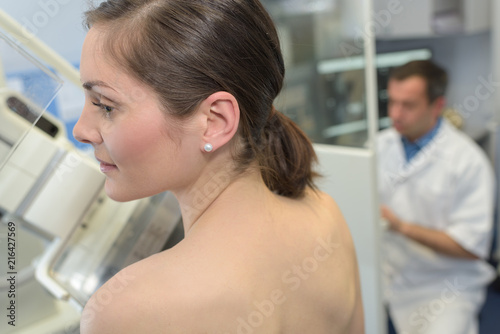 doctor assisting patient undergoing mammogram