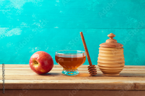 Honey and apple on wooden table