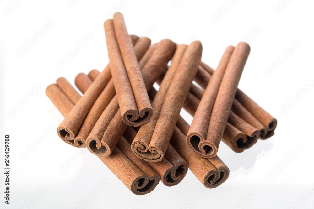 Heap of dry cinnamon sticks on white background