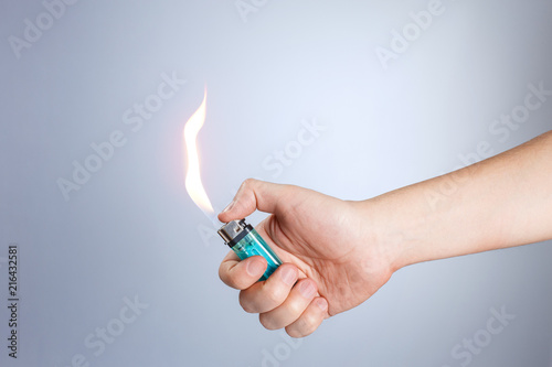 Hand burning a lighter on white background photo