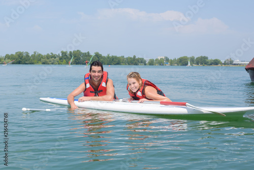 young couple swiming with paddle board in a lake © auremar