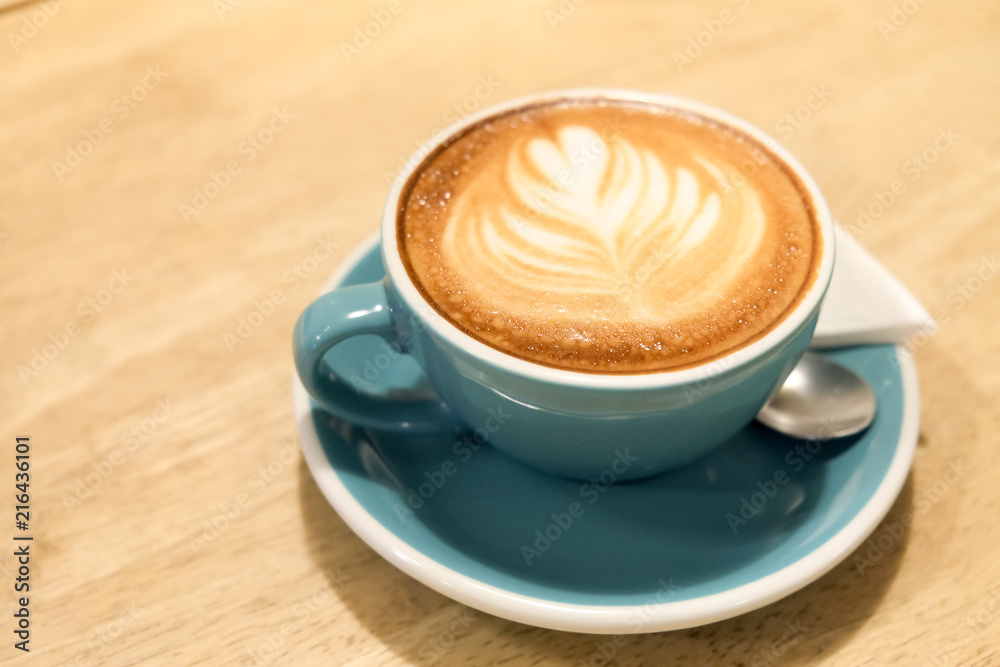 A cup of coffee Latte art green glass on wood table A cup of coffee Latte art green glass on wood table