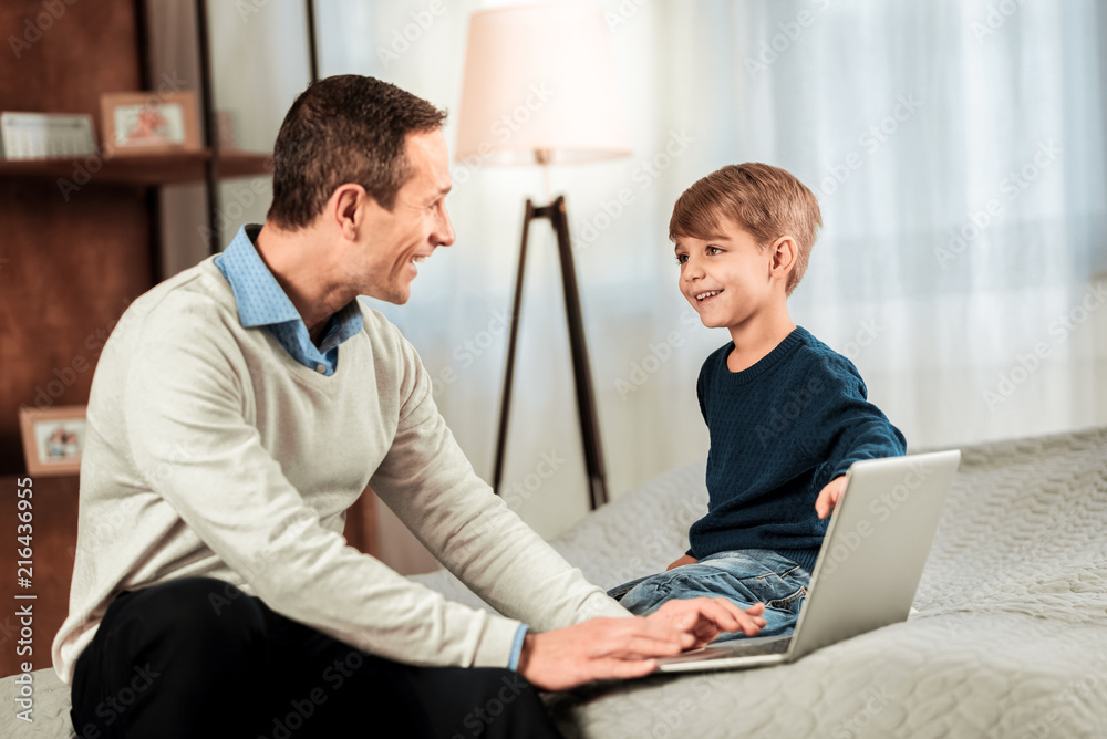 Happy mood. Positive joyful father and son smiling to each other while being in a wonderful mood Happy mood. Positive joyful father and son smiling to each other while being in a wonderful mood