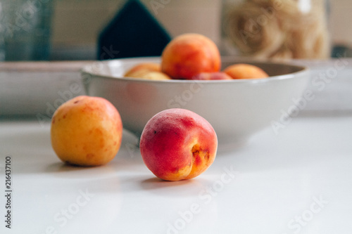 Fresh peaches on the white kitchen table. Local market products. Filtered image