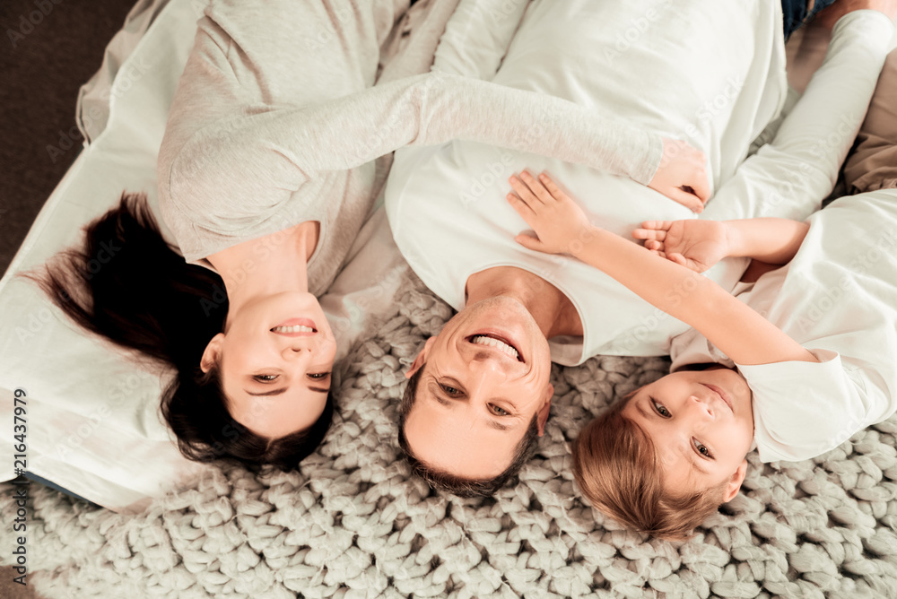 United family. Joyful delighted family lying together while smiling to you