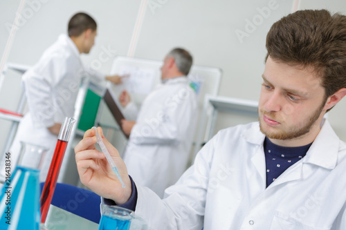 male chemist student performing an experiment