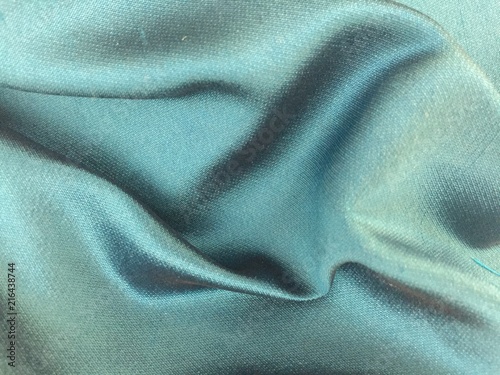 Woven texture of silk fabric or yarn turquois beige color changeable for background. Draped folded satin.