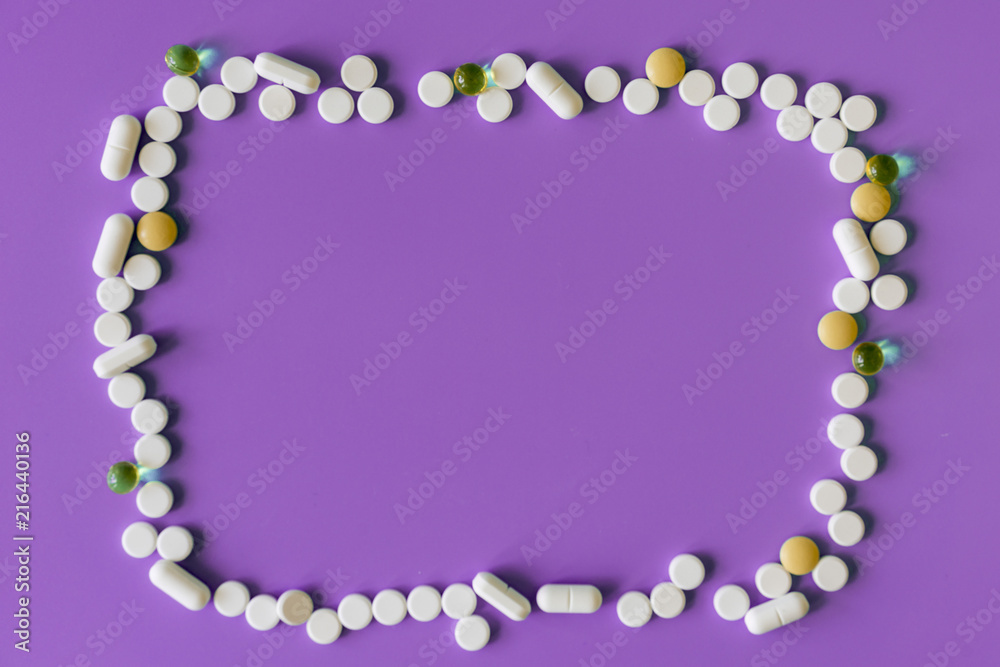 Obraz premium Frame of pills on a purple background. Pills for design. Concept of health, healthy lifestyle. Copy space for advertisement.