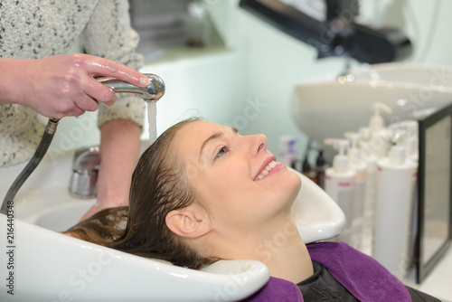 Woman enjoying having her hair washed in salon