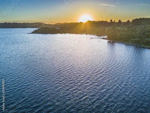 Rupanco Lake, one of the Great lakes in Southern Chile with an amazing aerial view from the drone over Osorno and Puntiagudo Volcanoes surrounded by the water and the trees during the sunset, Chile photo