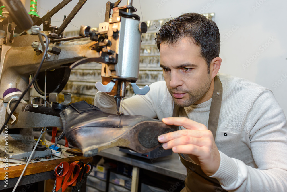 male specialist fixing heel taps of shoes on machine male specialist fixing heel taps of shoes on machine