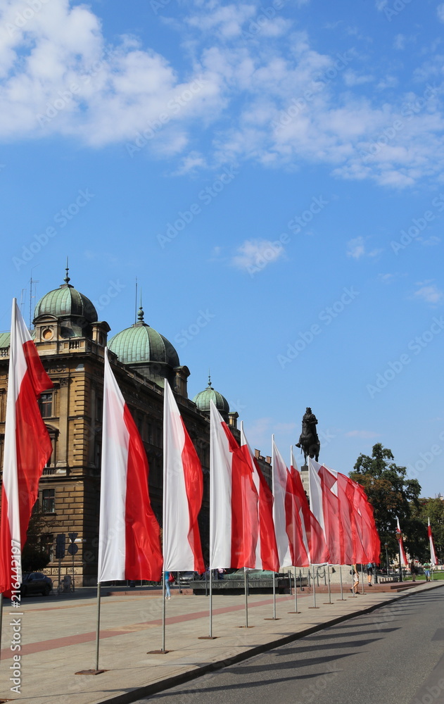 Obraz premium Vertical Polish flags, statue Pomnik Grunwaldzki