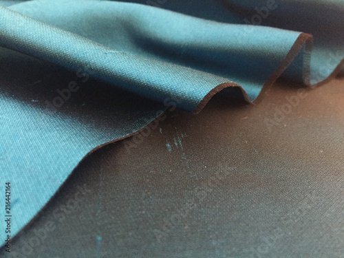 Woven texture of silk fabric or yarn turquois beige color changeable for background. Advertising copy space. Crumbling edge. Draped folded satin.