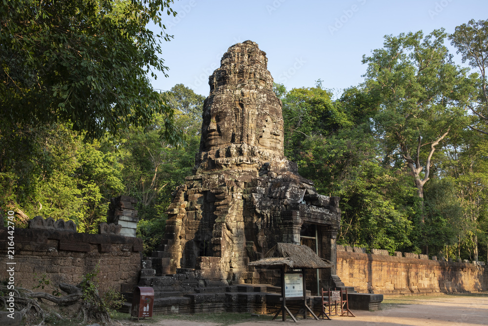 Ancient ruins of Ta Prohm temple in Angkor Wat complex, Cambodia. Tower with Buddha face. Stone temple ruin.