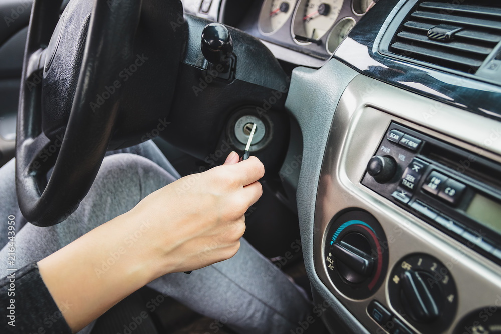 The girl starts the car, inserting the ignition key. The girl starts the car, inserting the ignition key.