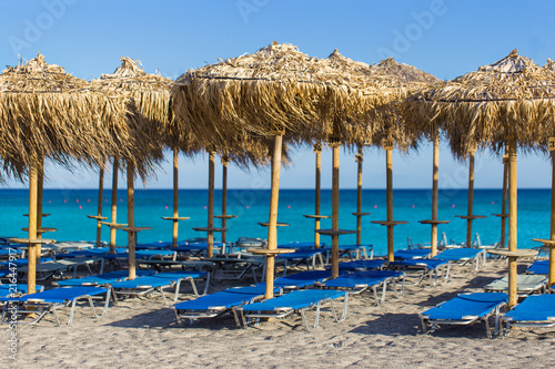 Empty sunbeds and umbrellas at the picturesque beach with white sand  Falassarna  Crete