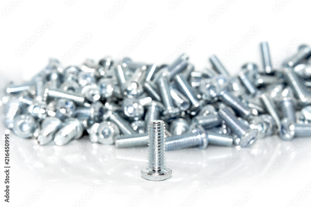 Single galvanized screw in front of a pile on white background Single galvanized screw in front of a pile on white background