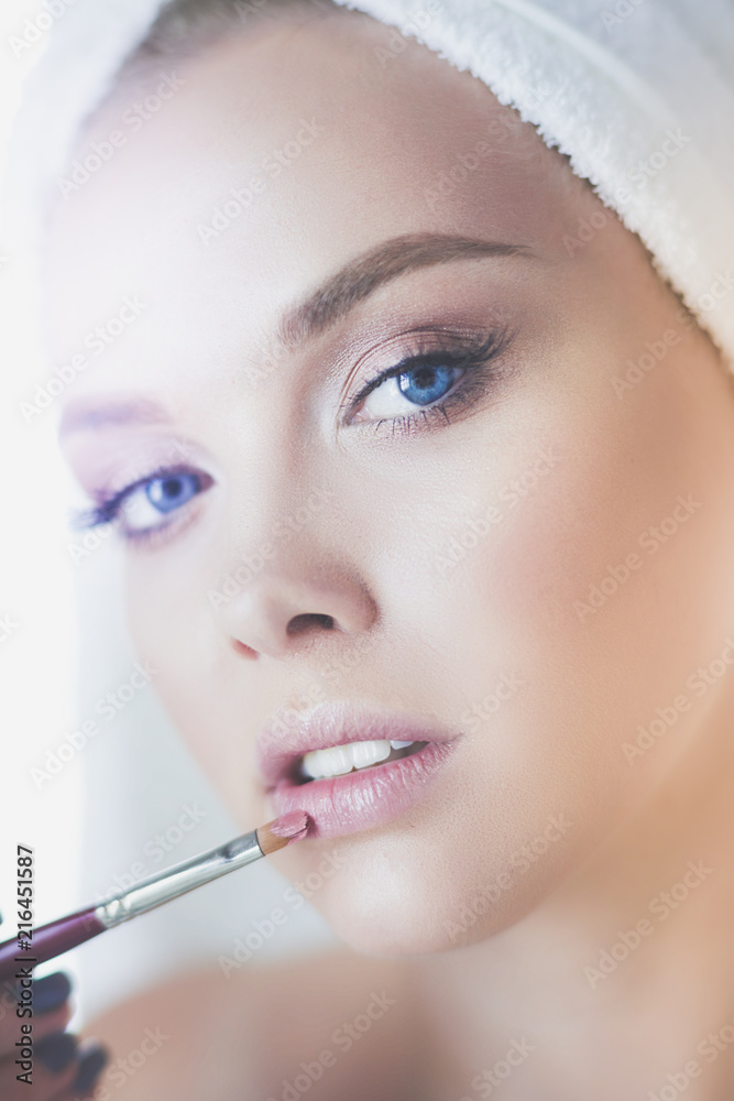 Young beautiful woman making make-up near mirror, in bathroom Young beautiful woman making make-up near mirror, in bathroom