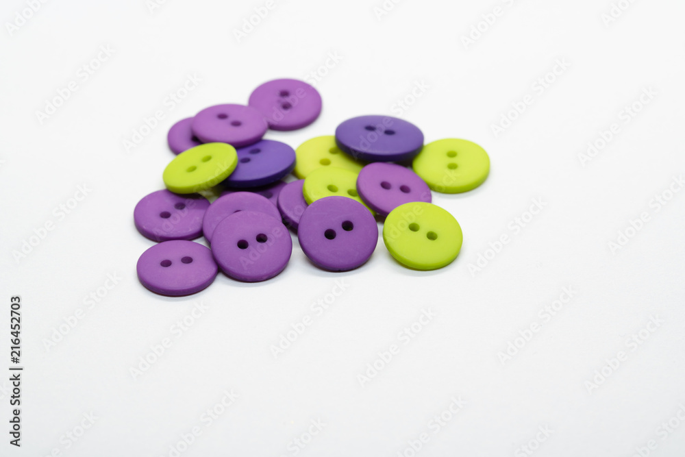 Pile of purple and green buttons isolated on white background. Pile of purple and green buttons isolated on white background.