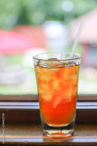 Drink for hot summer days. Fresh ice tea in a glass on a wooden desk