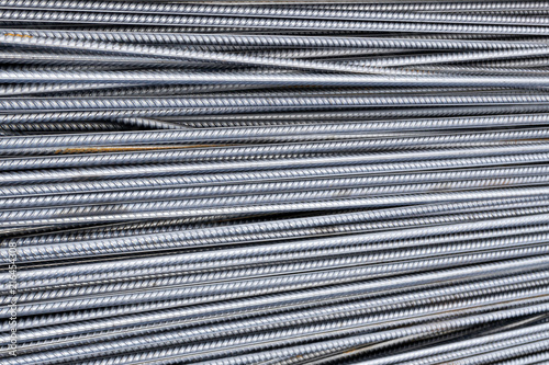 Stack of heavy metal reinforcement bars with periodic profile texture. Close up steel construction armature. Abstract industrial background concept. Copy space.