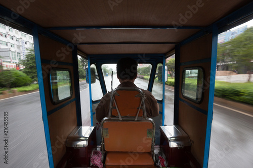 Inside Moving China Mini Car 3-Wheel Passenger Motorcycle - Chinese Commercial Tricycle for passengers, auto Rickshaw. Hybrid motorcycle car, metal frame three wheel vehicle for transportation © Cedar