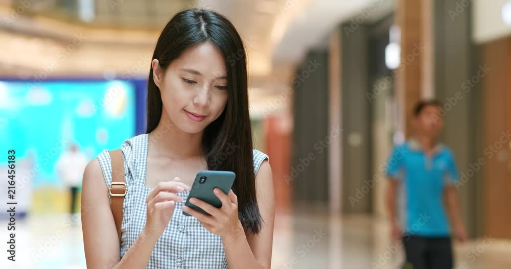 Woman use of smart phone in shopping mall Woman use of smart phone in shopping mall