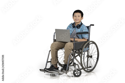 Preteen student with laptop in a wheelchair