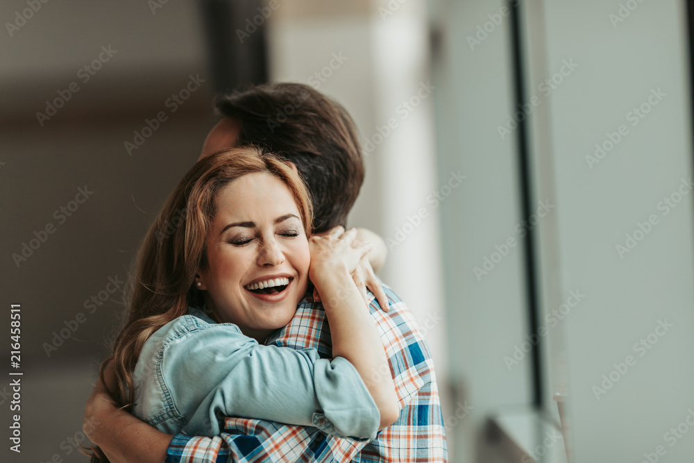 Laughing lady with attractive smile embracing man. Satisfied lovers concept Laughing lady with attractive smile embracing man. Satisfied lovers concept