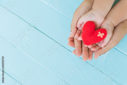 Top view of adult and child holding red heart in hands, Happy family relationships, Valentine's day, Mother's Day, Love and health care concept. photo