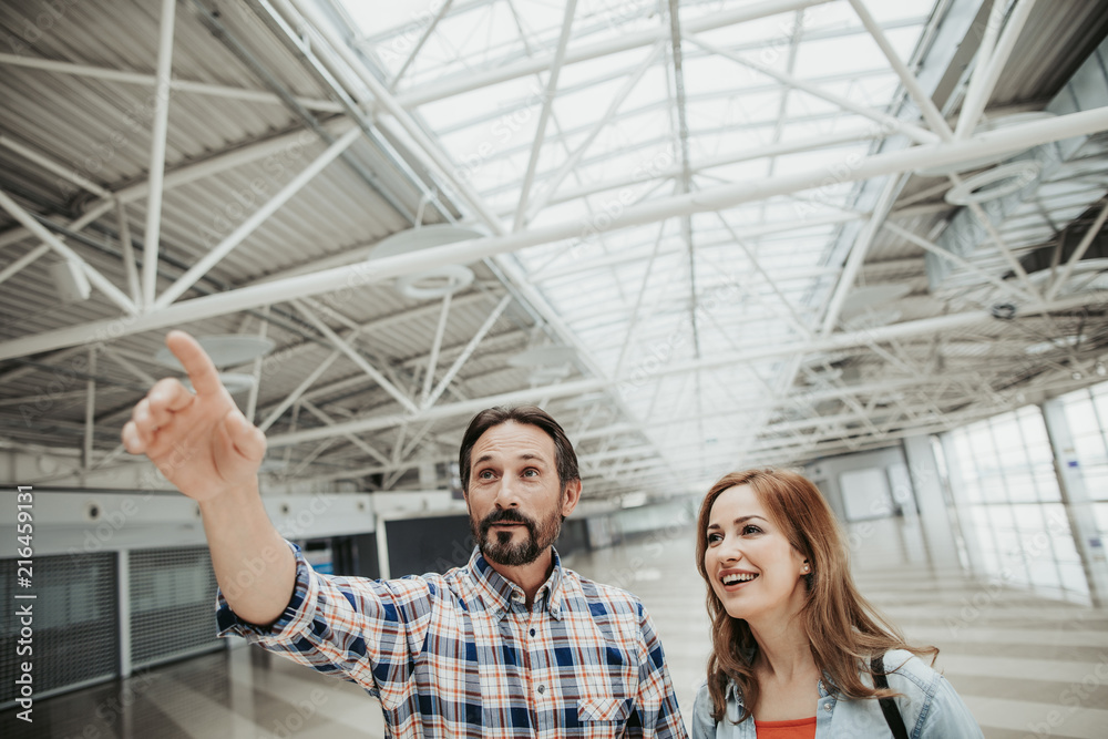 Portrait of happy bearded man gesticulating hands while telling with laughing girl indoor. Glad conversation concept