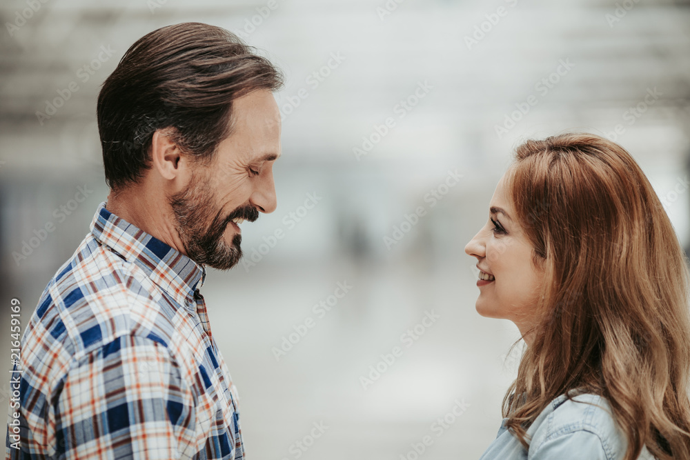 Side view smiling bearded man telling with cheerful girl. Happy conversation concept Side view smiling bearded man telling with cheerful girl. Happy conversation concept