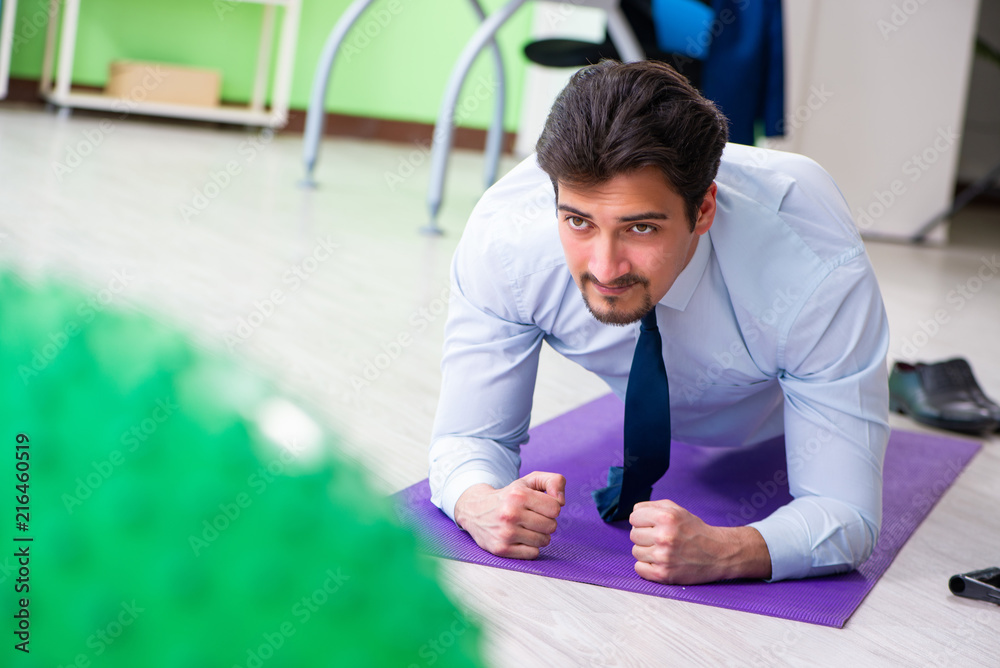 Fototapeta premium Employee doing exercises during break at work
