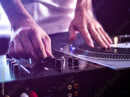 close up young dj playing modern music on professional equipment setup toned