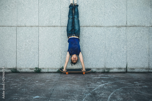 Fototapeta Sportswoman doing a handstand against a marble wall