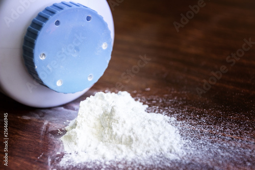 Baby talcum powder container on wooden background photo