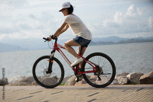 Woman riding a bike on sunny seaside © lzf