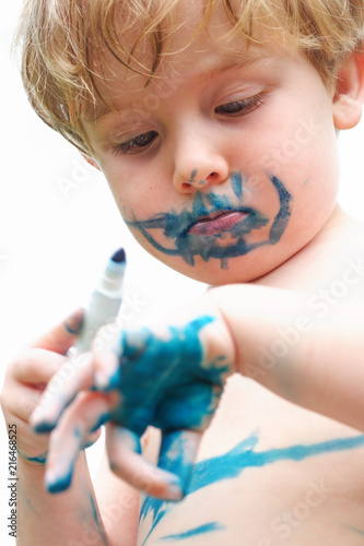 Young boy drawing on himself with a marker