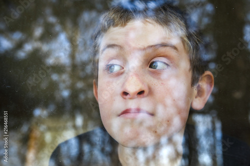 Canvas Print Boy pressing his nose on the window looking out