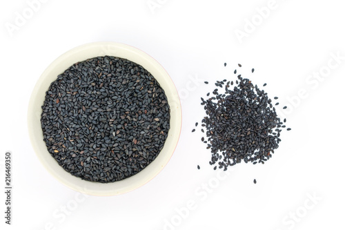Black sesame in white bowl on white background top view.