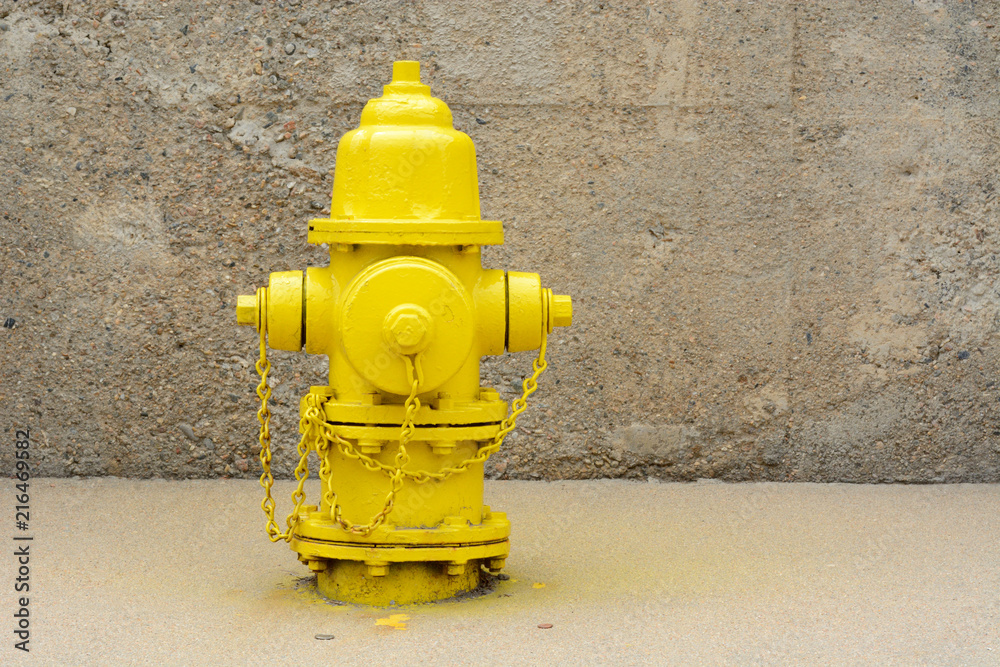 Urban landscape of bright yellow fire hydrant in concrete alcove Urban landscape of bright yellow fire hydrant in concrete alcove