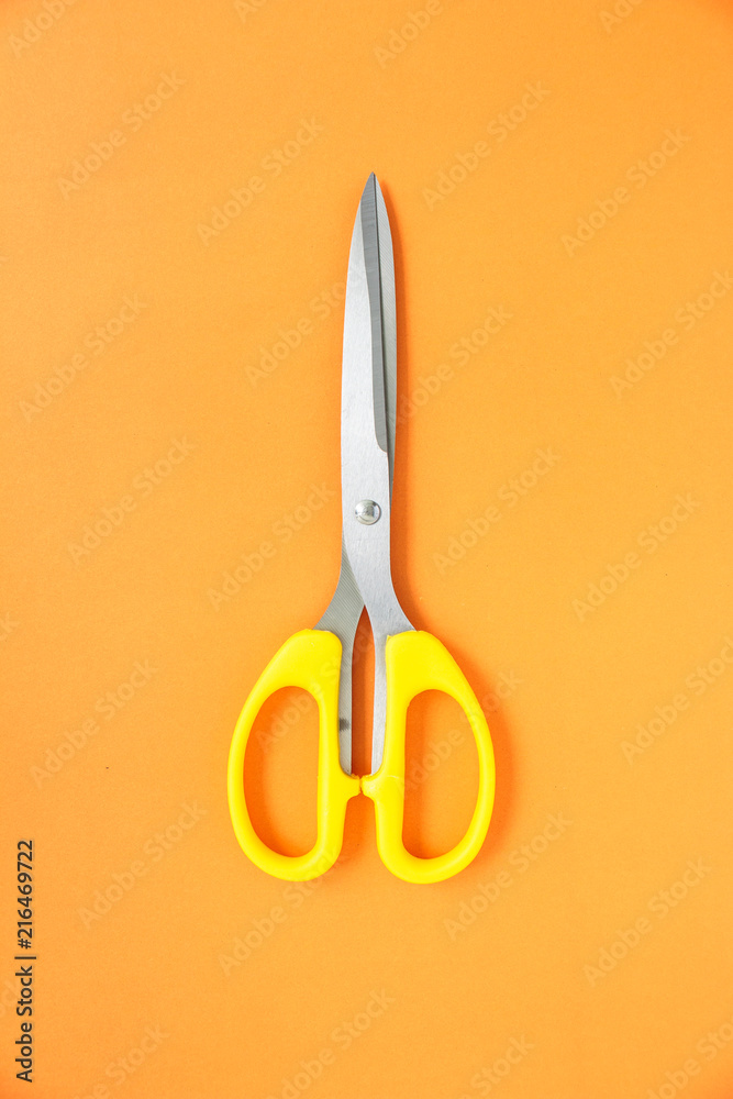 yellow scissors cutting on orange background yellow scissors cutting on orange background