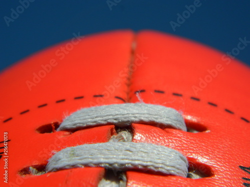 Close up of an Australian rules football on a blue sky background