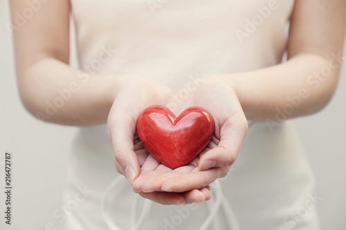 Young woman holding red heart  health insurance  donation  organ donor  compassion concept