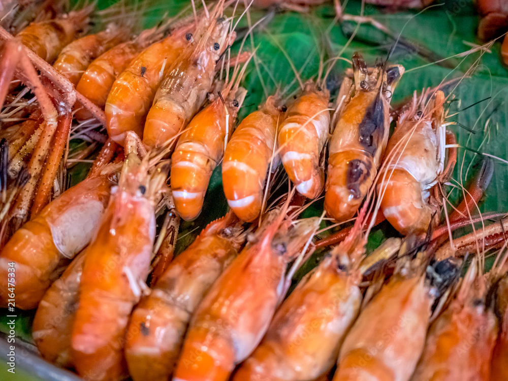 Grilled giant river prawn or big shrimp on banana leaf with selective focus.A recommended menu for tourists when they come to Thailand. The prawn is served with spicy seafood sauce. Grilled giant river prawn or big shrimp on banana leaf with selective focus.A recommended menu for tourists when they come to Thailand. The prawn is served with spicy seafood sauce.