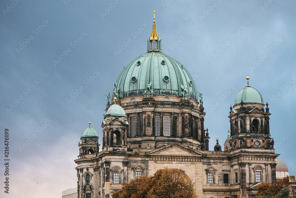 The Berlin Cathedral is called Berliner Dom against the backdrop of the setting sun. Beautiful old building in the style of neoclassicism and baroque with cross and sculptures. Berlin, Germany