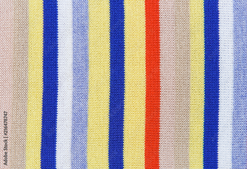 Closeup knitted beige, yellow, blue, white, light blue, red and grey color textile as background
