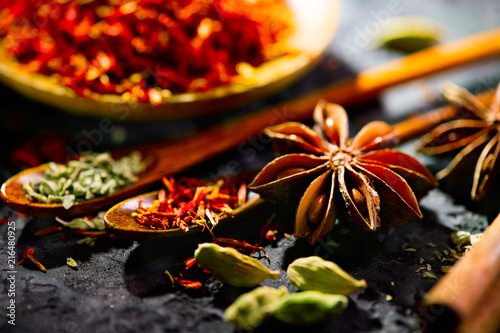 Fototapeta Naklejka Na Ścianę i Meble -  Spices. Various Indian spices on black stone table. Spice and herbs on slate background. Cooking ingredients