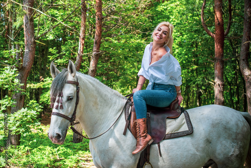 Pretty girl lady at countryside with white horse. A beautiful rider and horse. Artistic Photography at horse farm. Attractive girl riding on horse rural location 